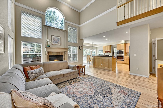 14878 E Aberdeen Ave, Centennial, CO 80016 - living room with crown molding, light wood-type flooring, healthy amount of natural light, a high ceiling, and a tile fireplace