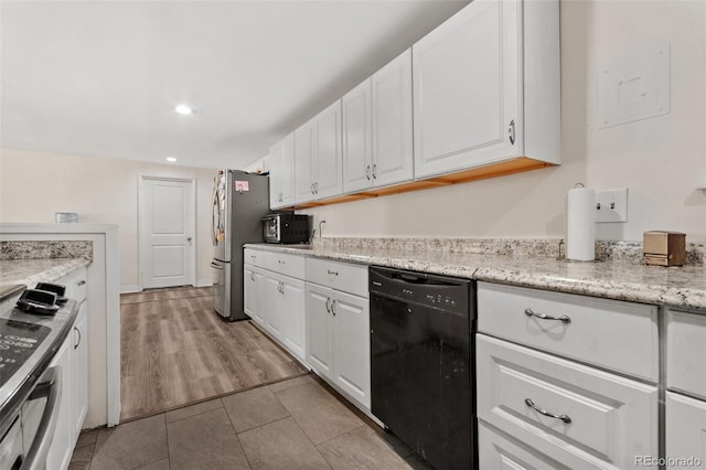 kitchen with dishwasher, light wood-type flooring, white cabinets, light stone counters, and stainless steel refrigerator