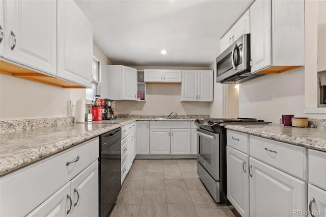 kitchen featuring light stone counters, stainless steel appliances, sink, and white cabinets