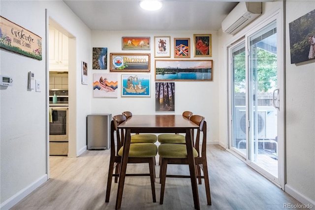 2557 S Dover St Unit 85, Lakewood, CO 80227 - dining area with an AC wall unit, light wood-type flooring, and baseboards