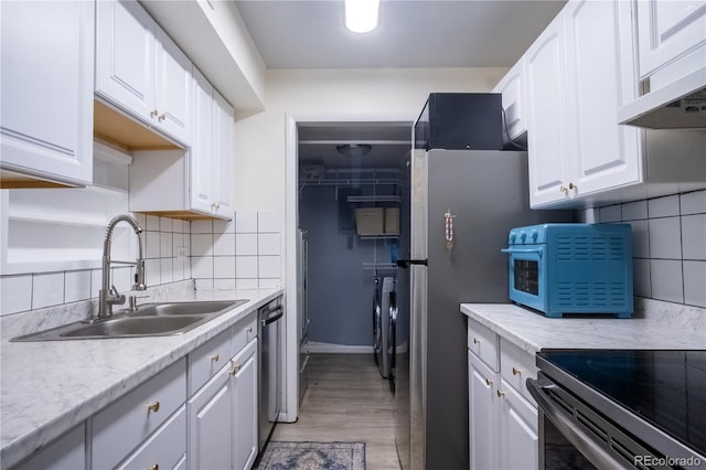 2557 S Dover St Unit 85, Lakewood, CO 80227 - kitchen featuring a sink, decorative backsplash, white cabinetry, under cabinet range hood, and light countertops