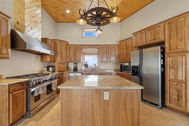 kitchen featuring appliances with stainless steel finishes, light stone counters, pendant lighting, a center island, and sink