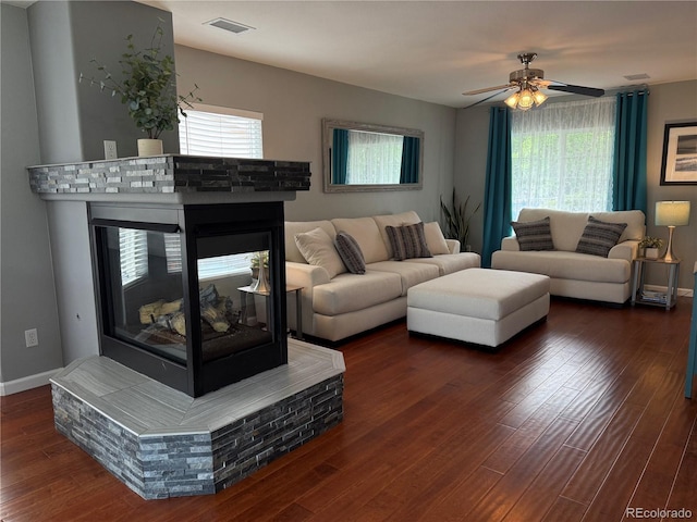15353 E 98th Pl, Commerce City, CO 80022 - living room with wood finished floors, a ceiling fan, and a multi sided fireplace