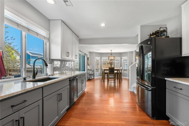 15353 E 98th Pl, Commerce City, CO 80022 - kitchen with freestanding refrigerator, stainless steel dishwasher, gray cabinets, light wood-style flooring, and recessed lighting