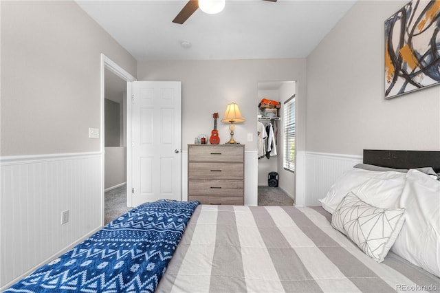 15353 E 98th Pl, Commerce City, CO 80022 - carpeted bedroom featuring a wainscoted wall, a walk in closet, a ceiling fan, and a closet