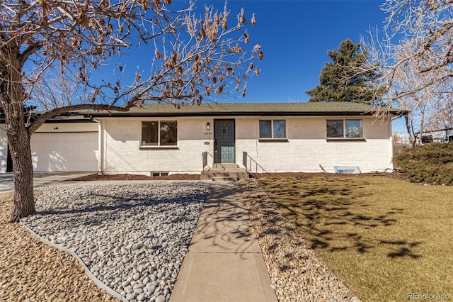 single story home featuring a garage, concrete driveway, brick siding, and a front lawn