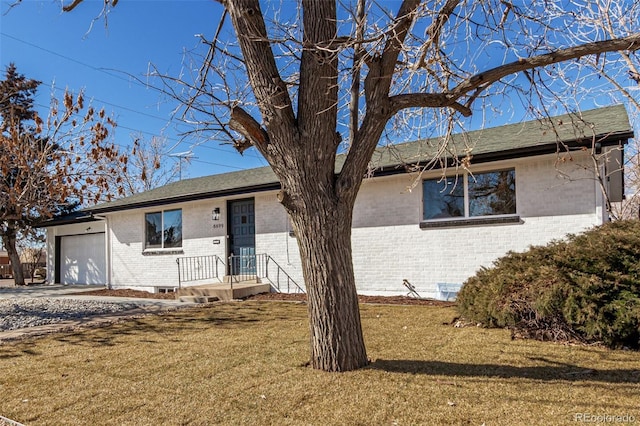 single story home with a front yard, brick siding, and an attached garage