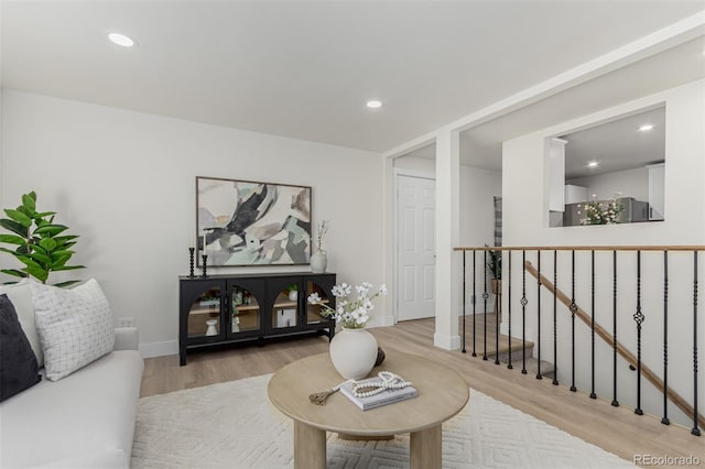 living area featuring baseboards, wood finished floors, and recessed lighting