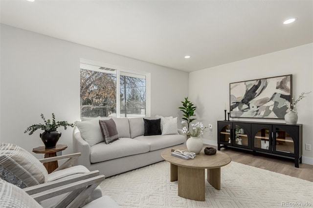 living area with recessed lighting, baseboards, and wood finished floors