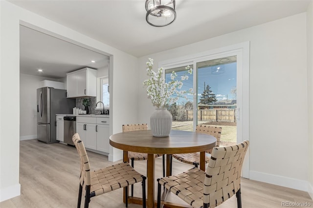 dining space featuring light wood-type flooring, baseboards, and recessed lighting