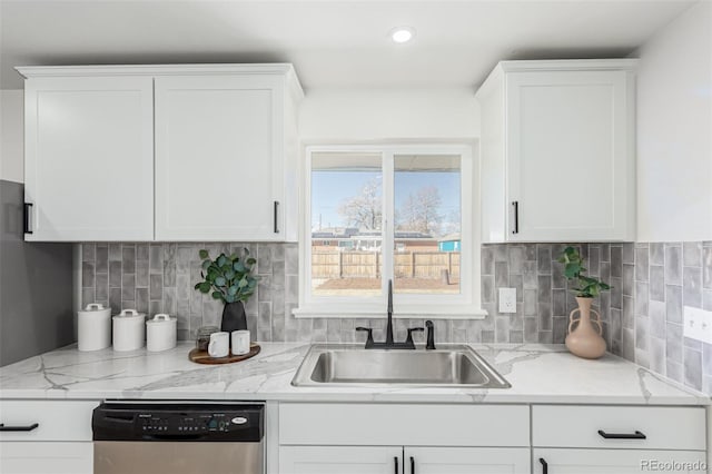 kitchen with a sink, white cabinetry, backsplash, and stainless steel dishwasher