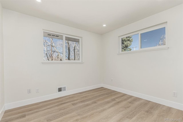 unfurnished room with light wood-style floors, recessed lighting, visible vents, and baseboards