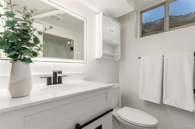 bathroom with visible vents, vanity, and toilet