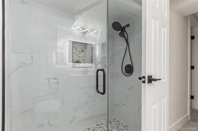 full bathroom featuring a marble finish shower and baseboards