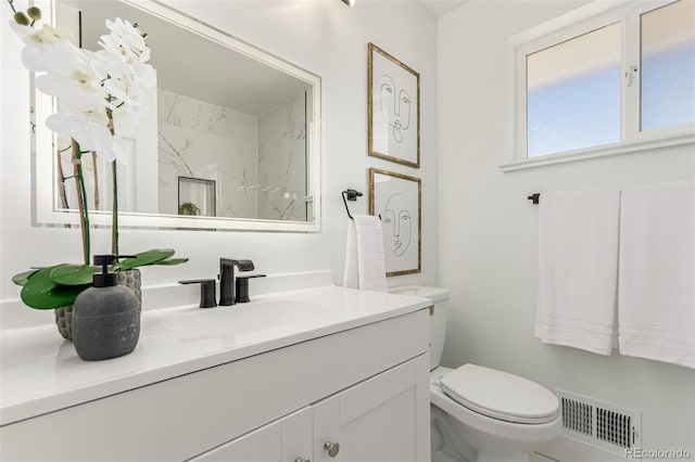 bathroom with toilet, visible vents, and vanity