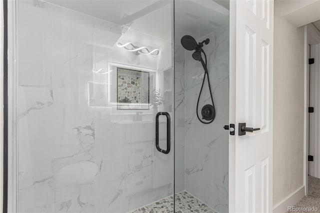 bathroom featuring a marble finish shower