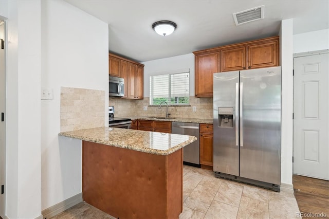 1420 S Leyden St, Denver, CO 80224 - kitchen with appliances with stainless steel finishes, a sink, brown cabinets, and a peninsula