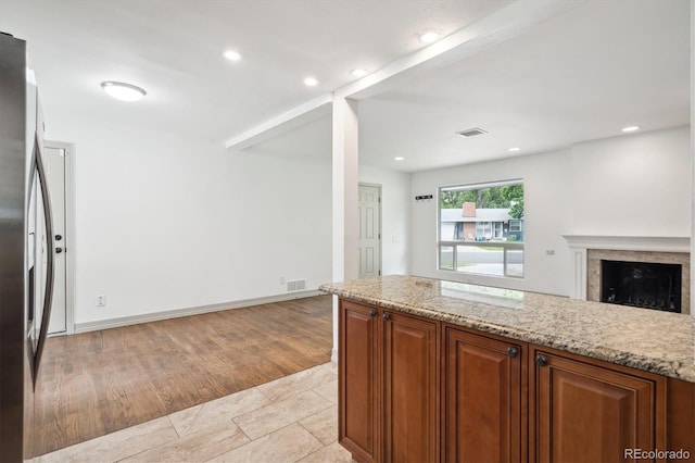 1420 S Leyden St, Denver, CO 80224 - kitchen featuring stainless steel fridge, open floor plan, light stone countertops, a fireplace, and recessed lighting