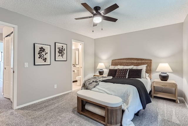 bedroom with carpet flooring, ceiling fan, a textured ceiling, and ensuite bath