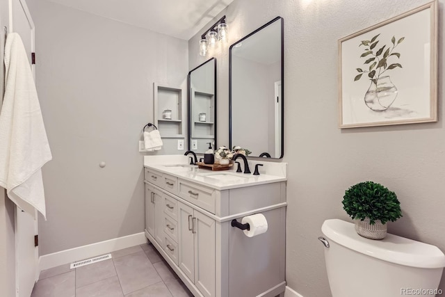 bathroom featuring vanity, toilet, and tile patterned flooring