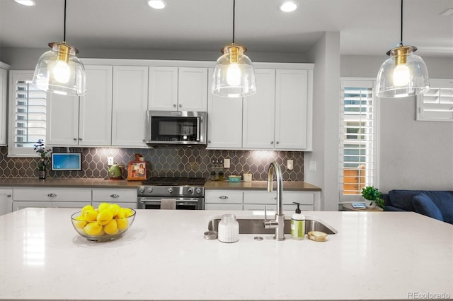 4535 W 50th Ave, Denver, CO 80212 - kitchen featuring stainless steel appliances, a sink, decorative backsplash, white cabinets, and recessed lighting