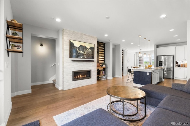 4535 W 50th Ave, Denver, CO 80212 - living area featuring wood finished floors, baseboards, a large fireplace, recessed lighting, and stairway