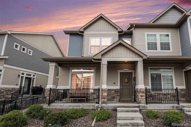 20000 E 40th Ave Unit 4, Denver, CO 80249 - view of front facade with a porch, stone siding, board and batten siding, and stucco siding