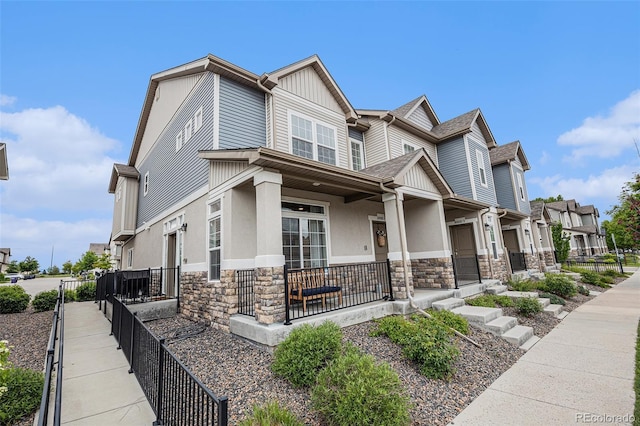 20000 E 40th Ave Unit 4, Denver, CO 80249 - view of front facade with stone siding, a porch, stucco siding, and a residential view