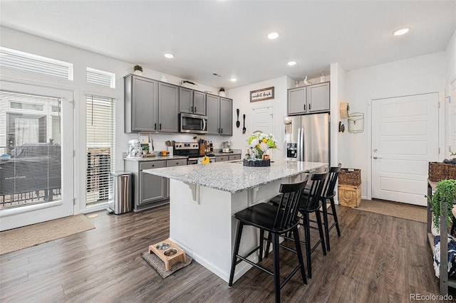 20000 E 40th Ave Unit 4, Denver, CO 80249 - kitchen featuring appliances with stainless steel finishes, gray cabinets, a breakfast bar, and recessed lighting