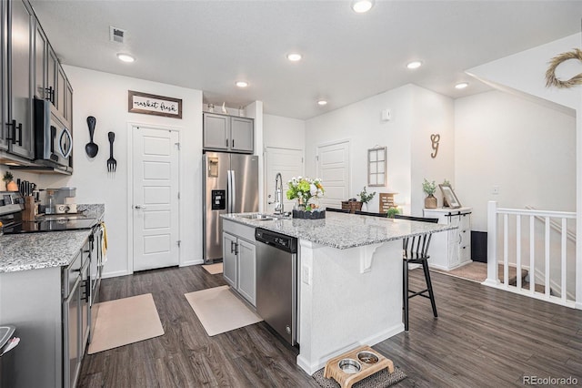 20000 E 40th Ave Unit 4, Denver, CO 80249 - kitchen featuring appliances with stainless steel finishes, a sink, dark wood-type flooring, light stone countertops, and recessed lighting