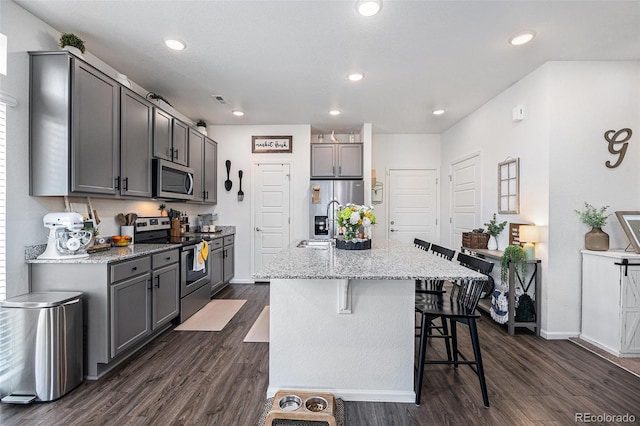 20000 E 40th Ave Unit 4, Denver, CO 80249 - kitchen with stainless steel appliances, dark wood-style flooring, a kitchen breakfast bar, baseboards, and recessed lighting