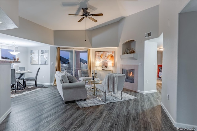 living room featuring a fireplace, high vaulted ceiling, dark hardwood / wood-style floors, and ceiling fan