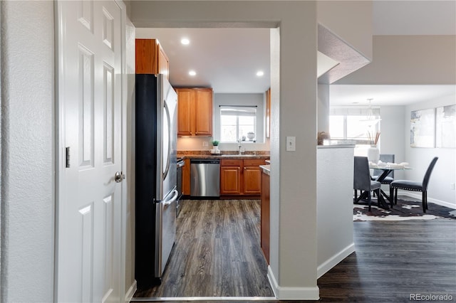 kitchen with appliances with stainless steel finishes, dark wood-type flooring, and sink