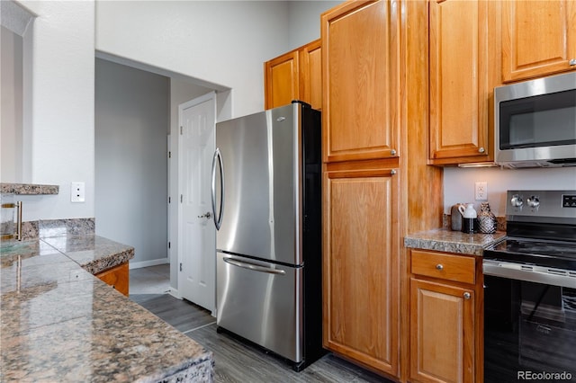 kitchen featuring stainless steel appliances and dark hardwood / wood-style flooring