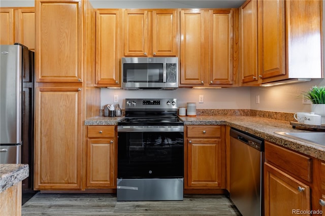 kitchen featuring dark wood-type flooring and appliances with stainless steel finishes