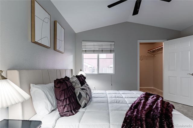 bedroom with light carpet, a walk in closet, lofted ceiling, and ceiling fan