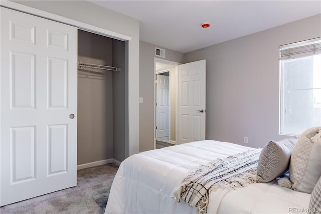 bedroom with light carpet and a closet