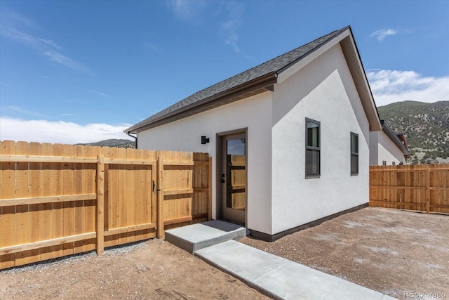 126 Chase St, Salida, CO 81201 - rear view of house with stucco siding, fence, a gate, and a mountain view