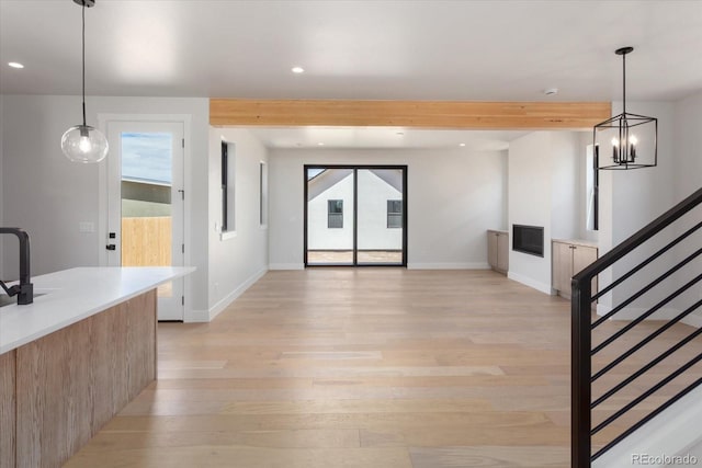126 Chase St, Salida, CO 81201 - unfurnished living room with recessed lighting, light wood-style floors, beam ceiling, baseboards, and stairway