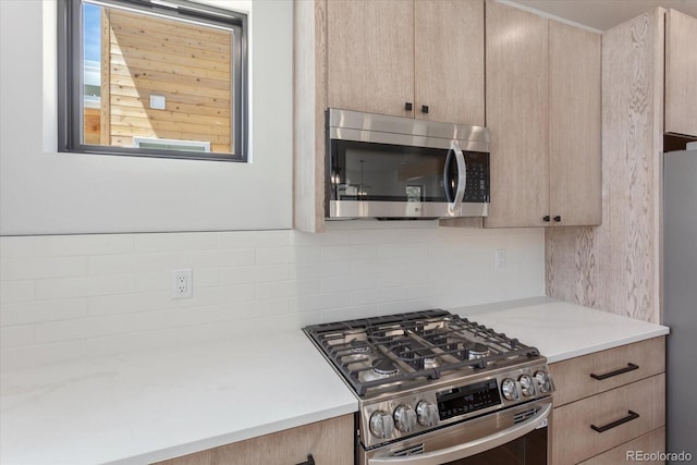 126 Chase St, Salida, CO 81201 - kitchen featuring appliances with stainless steel finishes, light brown cabinets, light countertops, and backsplash