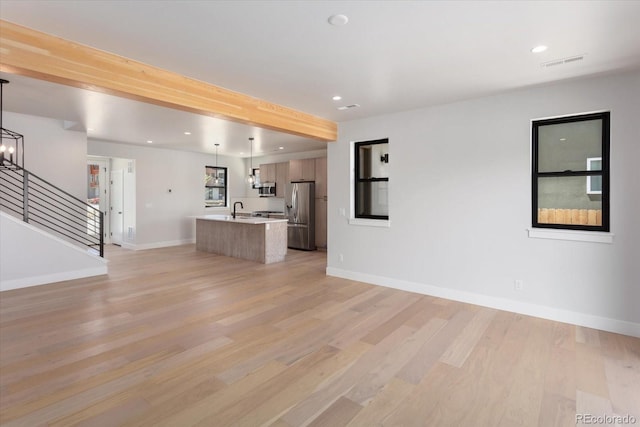 126 Chase St, Salida, CO 81201 - unfurnished living room featuring light wood-type flooring, a sink, recessed lighting, stairs, and baseboards