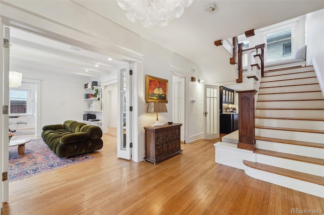 foyer entrance with light hardwood / wood-style flooring and a notable chandelier