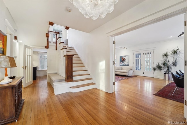 interior space with hardwood / wood-style floors, a notable chandelier, and french doors