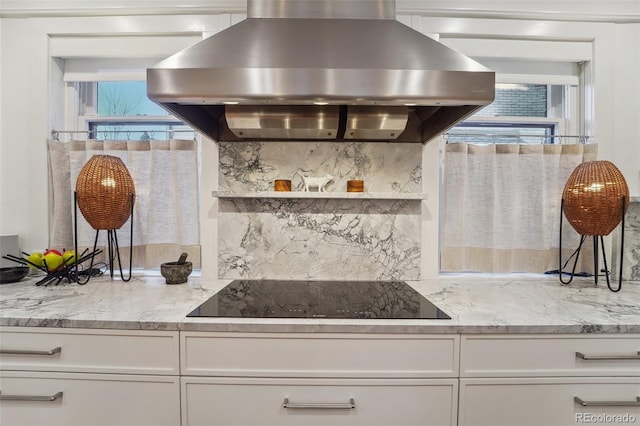 kitchen featuring white cabinets, black electric cooktop, and island exhaust hood