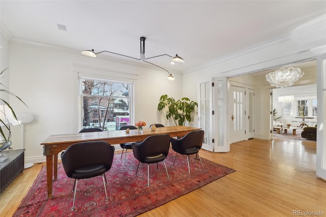 dining area featuring a chandelier, crown molding, and light hardwood / wood-style floors