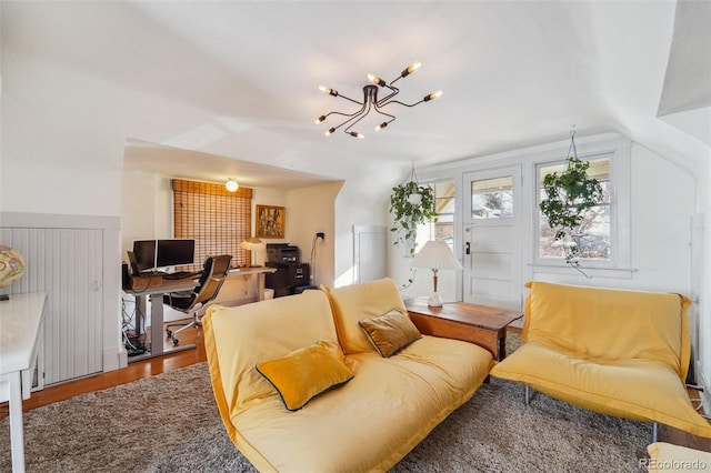 living room featuring wood-type flooring, an inviting chandelier, and lofted ceiling