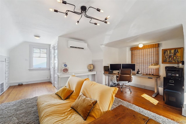 home office featuring light hardwood / wood-style floors, a wall mounted air conditioner, and lofted ceiling