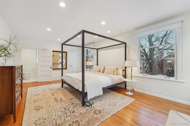 bedroom featuring light wood-type flooring and connected bathroom