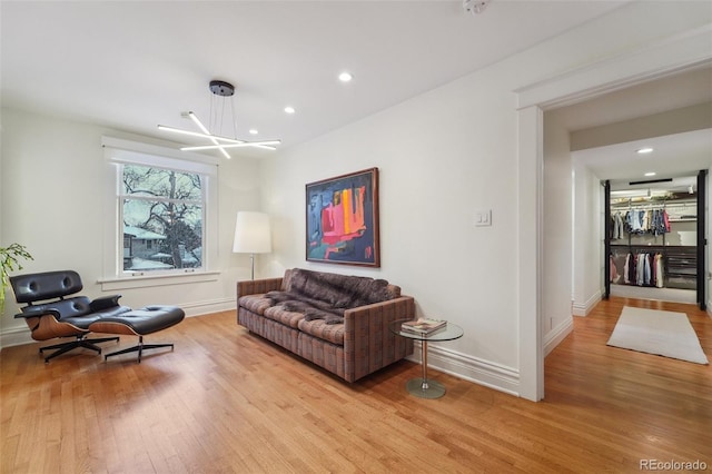 living area featuring light hardwood / wood-style flooring and an inviting chandelier