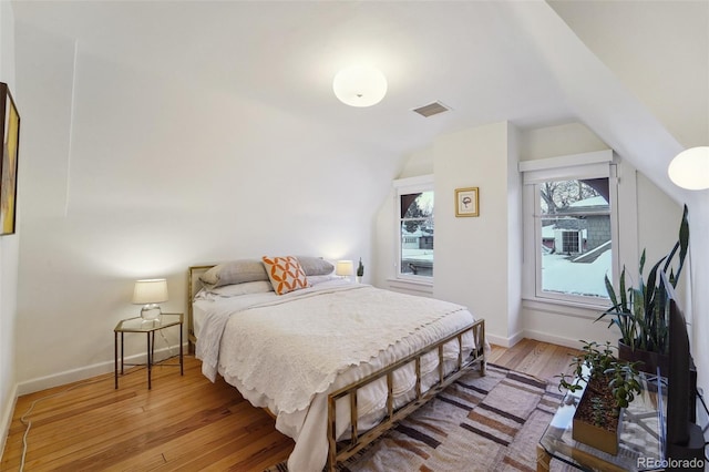 bedroom featuring light hardwood / wood-style floors and lofted ceiling